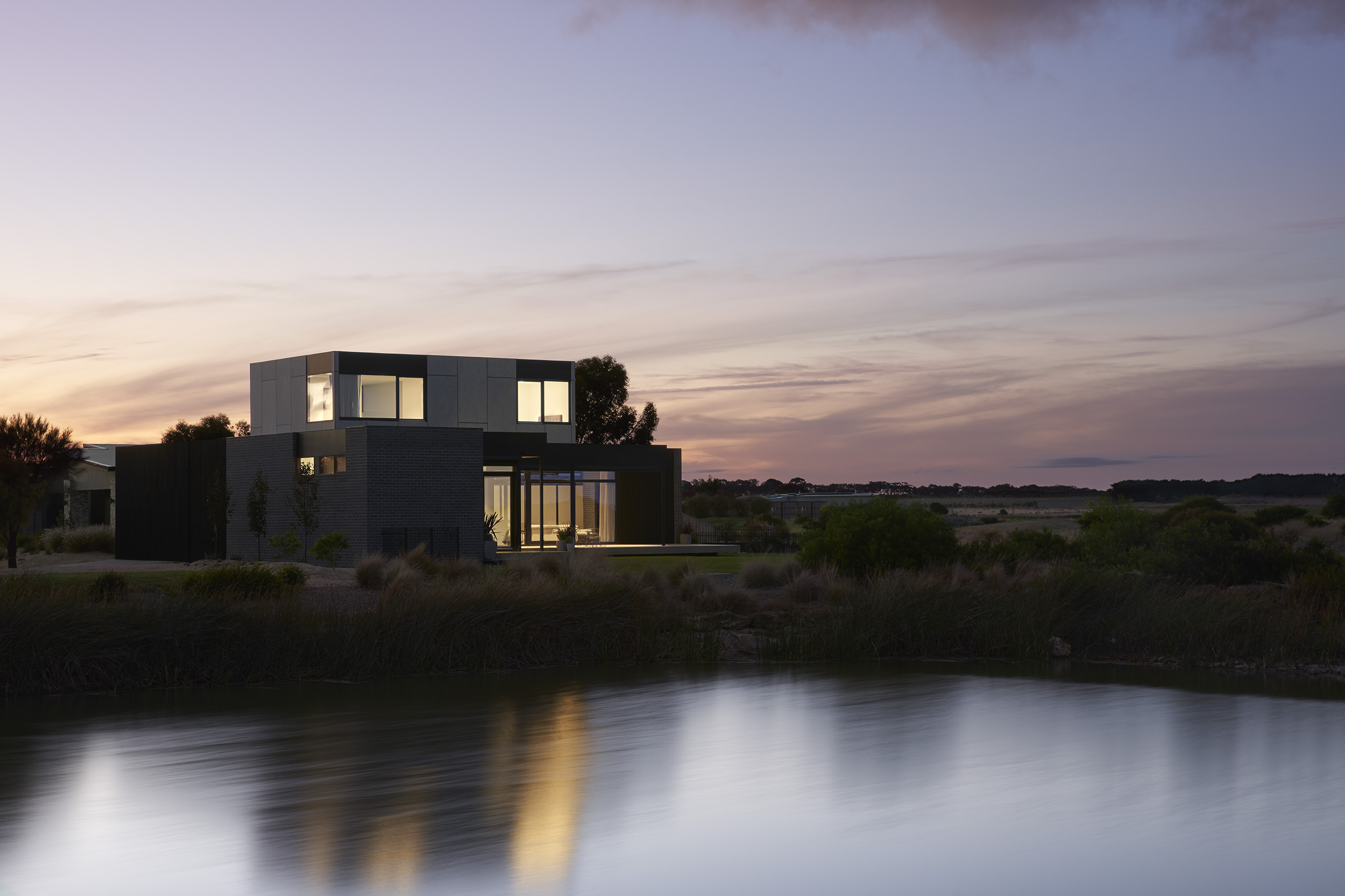 With Dark Brickwork Forming A Solid Base And A Barestone Clad Upper Section Creating A Textural Contrast